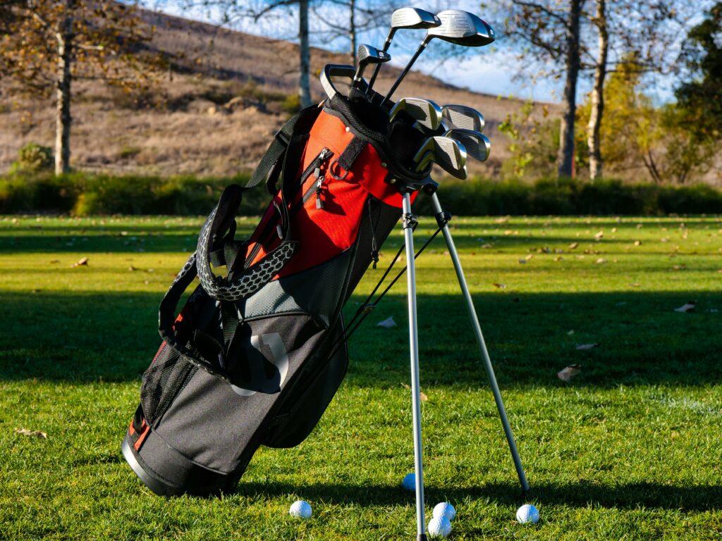 A set of custom golf clubs in a golf bag on a golf course